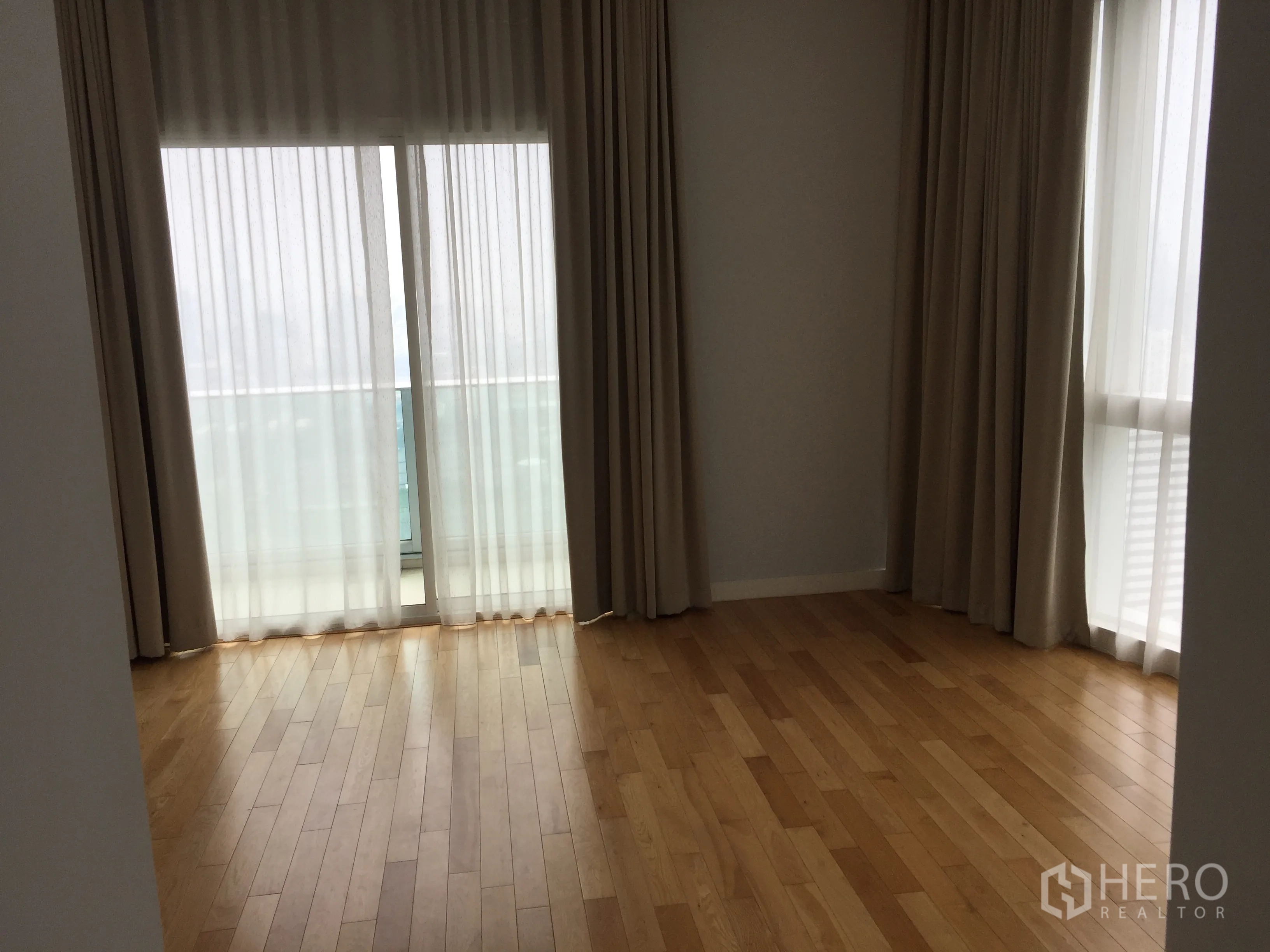 คอนโด ให้เช่าในKhlong Toei, Bangkok - ห้องนอนสว่างมุมกระจก ผ้าม่านสูงจรดเพดาน พื้นไม้ และประตูออกระเบียงวิวเมือง