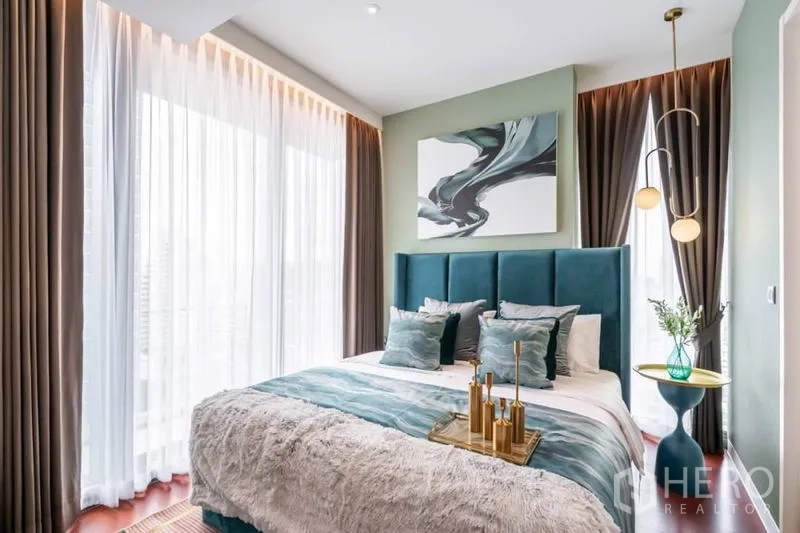 คอนโด ให้เช่าหรือขายในWatthana, Bangkok - ห้องนอนหลักรับแสงดี หัวเตียงกำมะหยี่สีเขียว โคมแขวน หน้าต่างมุม และผนังสีเขียวอ่อน