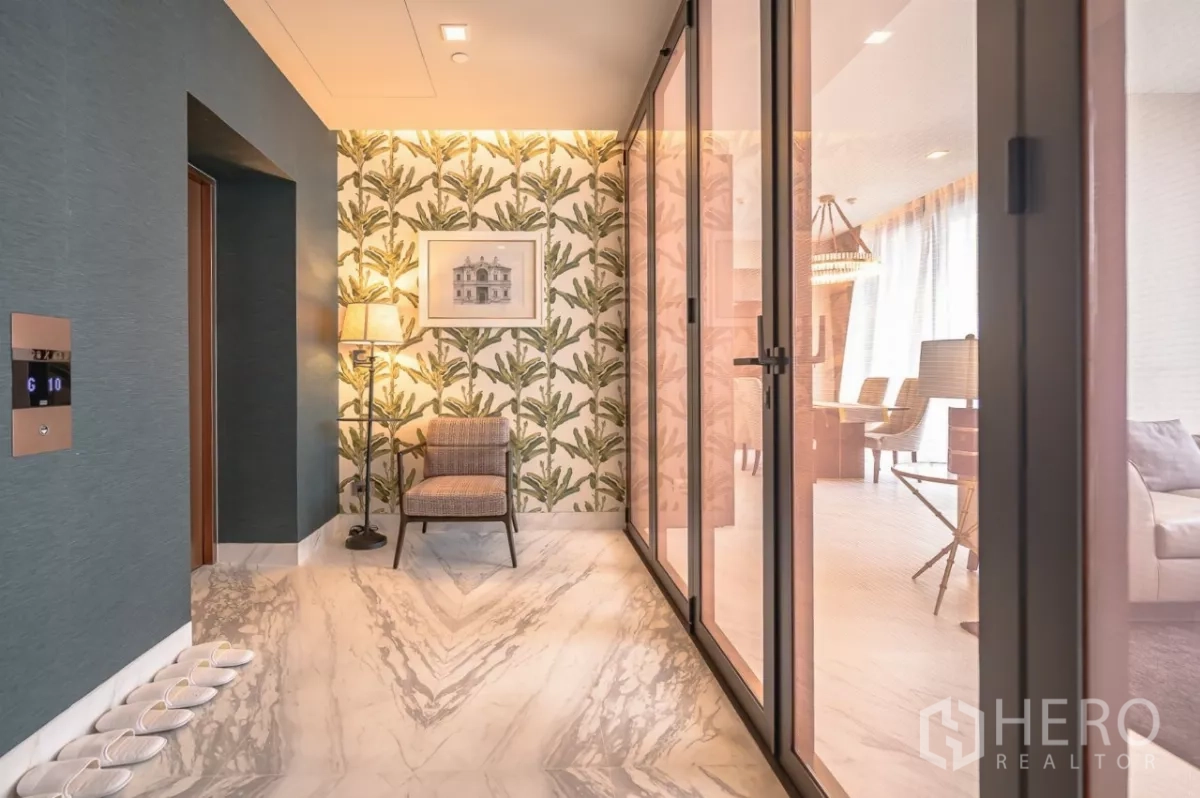公寓 出租在Watthana, Bangkok - 私家电梯前厅，热带风墙纸、单椅与通往房内的玻璃门。