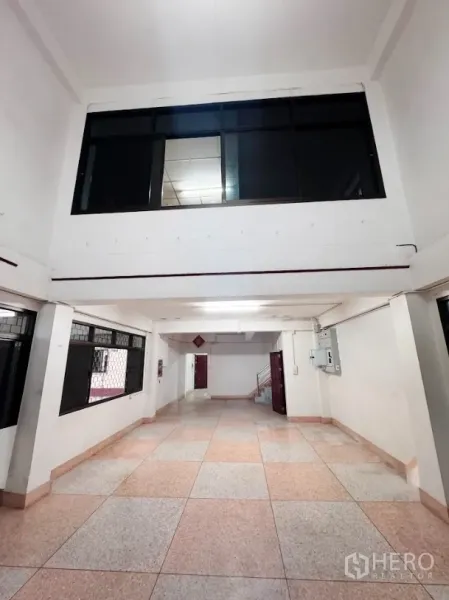 Warehouse for rent or sale in Thanyaburi, Pathum Thani - Ground-floor corridor office space with tiled floors and barred windows inside the warehouse.