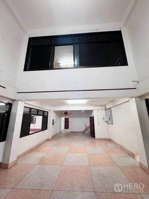 Warehouse for rent or sale in Thanyaburi, Pathum Thani - Ground-floor corridor office space with tiled floors and barred windows inside the warehouse.