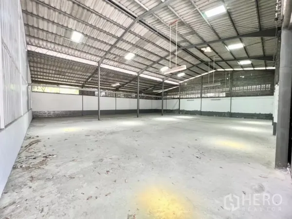货栈 出租在Mueang Samut Prakan, Samut Prakan - 仓库内部空间开阔，金属高屋顶与天窗，地面平整。