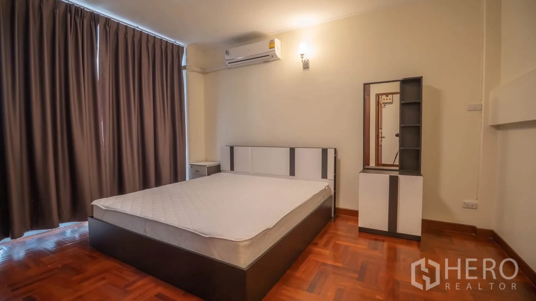 Townhouse for rent in Watthana, Bangkok - Another bedroom with bed, bedside table, vanity, and air conditioner.