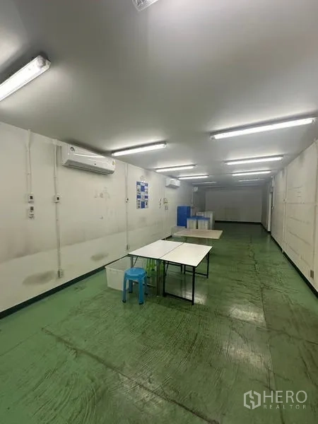 คลังสินค้า ให้เช่าหรือขายในLam Luk Ka, Pathum Thani - ห้องทำงานยาว มีโต๊ะ แอร์ และพื้นสีเขียว เหมาะสำหรับงานประกอบ