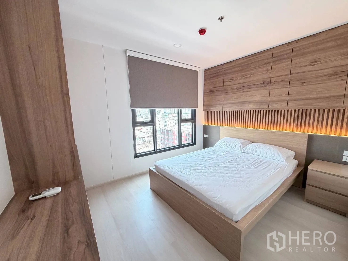 คอนโด for rent in Din Daeng, Bangkok - ห้องนอนสว่างพร้อมเตียงควีน หัวเตียงไม้ไฟซ่อน และหน้าต่างมู่ลี่ทึบแสง