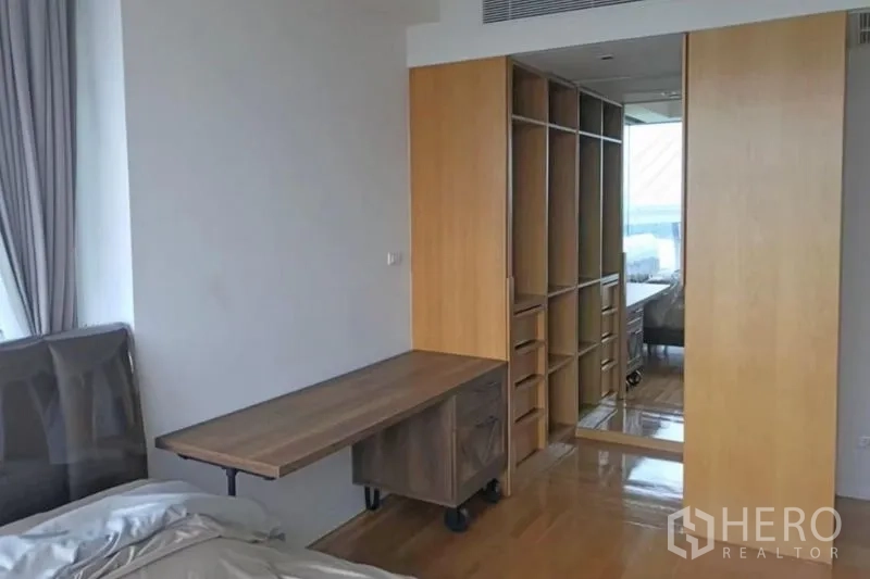 Condominium for rent or sale in Yan Nawa, Bangkok - Bedroom with built-in walk-in closet, sliding wood doors and study desk.