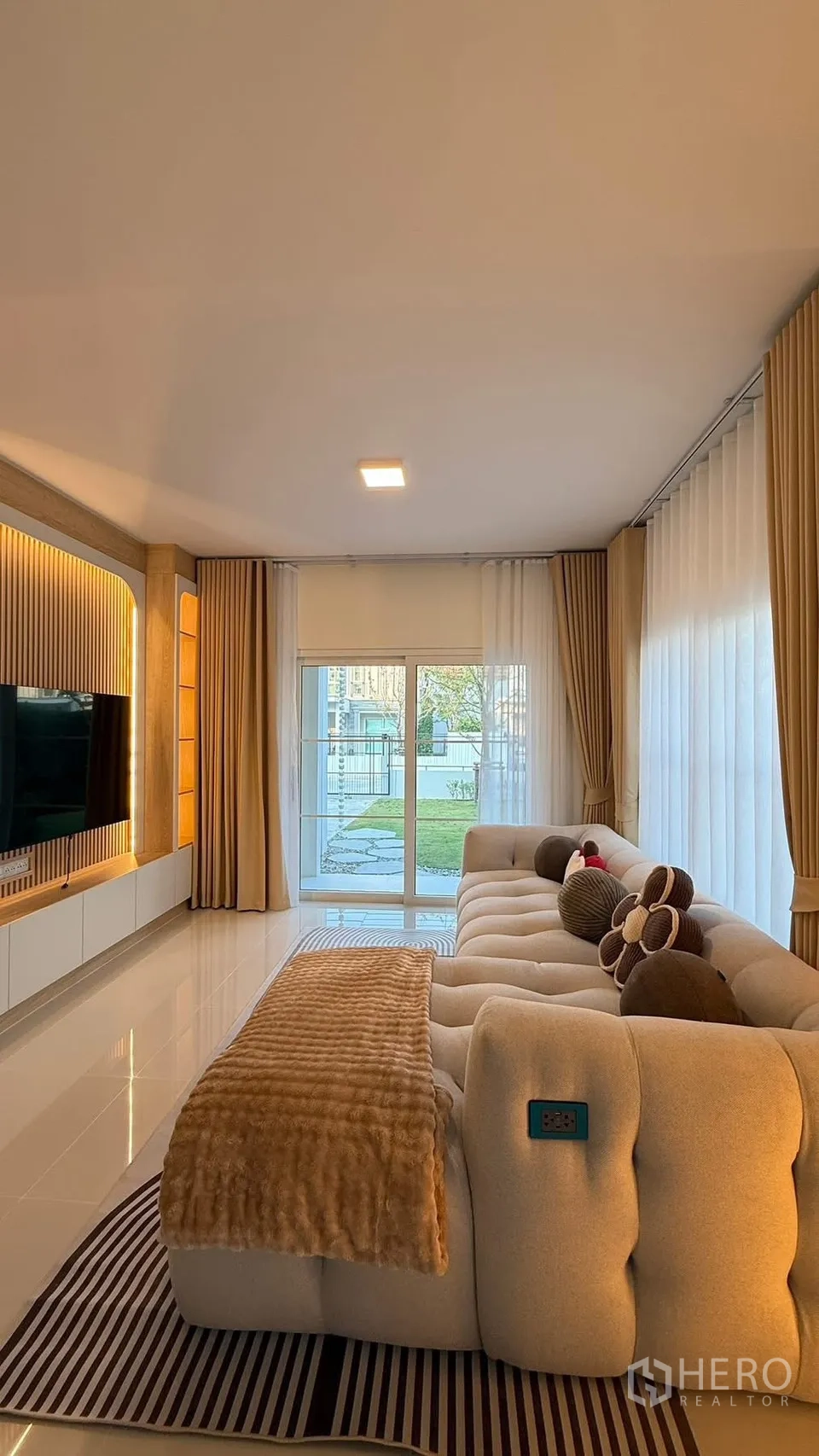 Detached House for rent in Bang Phli, Samut Prakan - Spacious living room with sectional sofa and sliding doors to the garden.