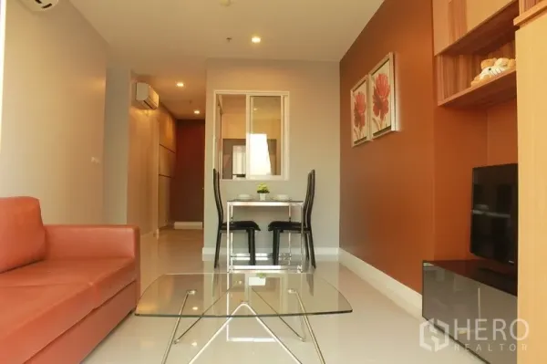 คอนโด ให้เช่าในWatthana, Bangkok - ห้องนั่งเล่นและรับประทานอาหารสว่าง โซฟาหนัง โต๊ะกลางกระจก ชั้นวางทีวี และผนังโทนอุ่น