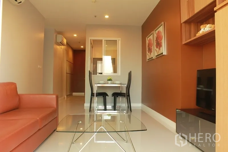 คอนโด ให้เช่าในWatthana, Bangkok - ห้องนั่งเล่นและรับประทานอาหารสว่าง โซฟาหนัง โต๊ะกลางกระจก ชั้นวางทีวี และผนังโทนอุ่น