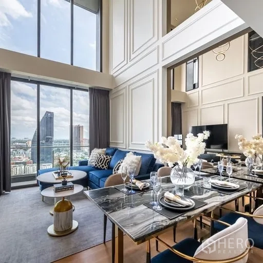 คอนโด ให้เช่าในKhlong Toei, Bangkok - พื้นที่รับประทานอาหารรองรับ 6 ที่นั่ง โต๊ะหินอ่อนสีดำ ข้างหน้าต่างสูง และโซฟาสีน้ำเงินในโถงโปร่ง