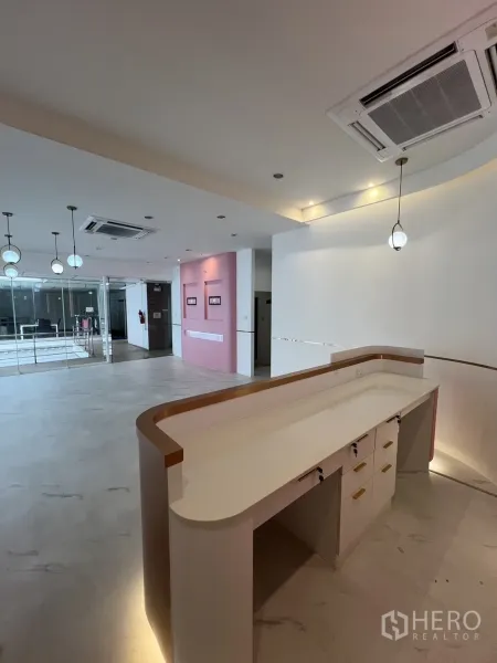 零售空间 出租在Watthana, Bangkok - 弧形内置接待台，开放式区域内配吊灯照明。