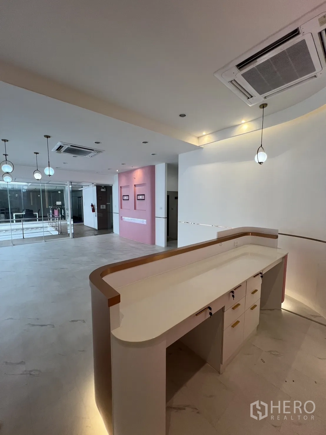 零售空间 出租在Watthana, Bangkok - 弧形内置接待台，开放式区域内配吊灯照明。