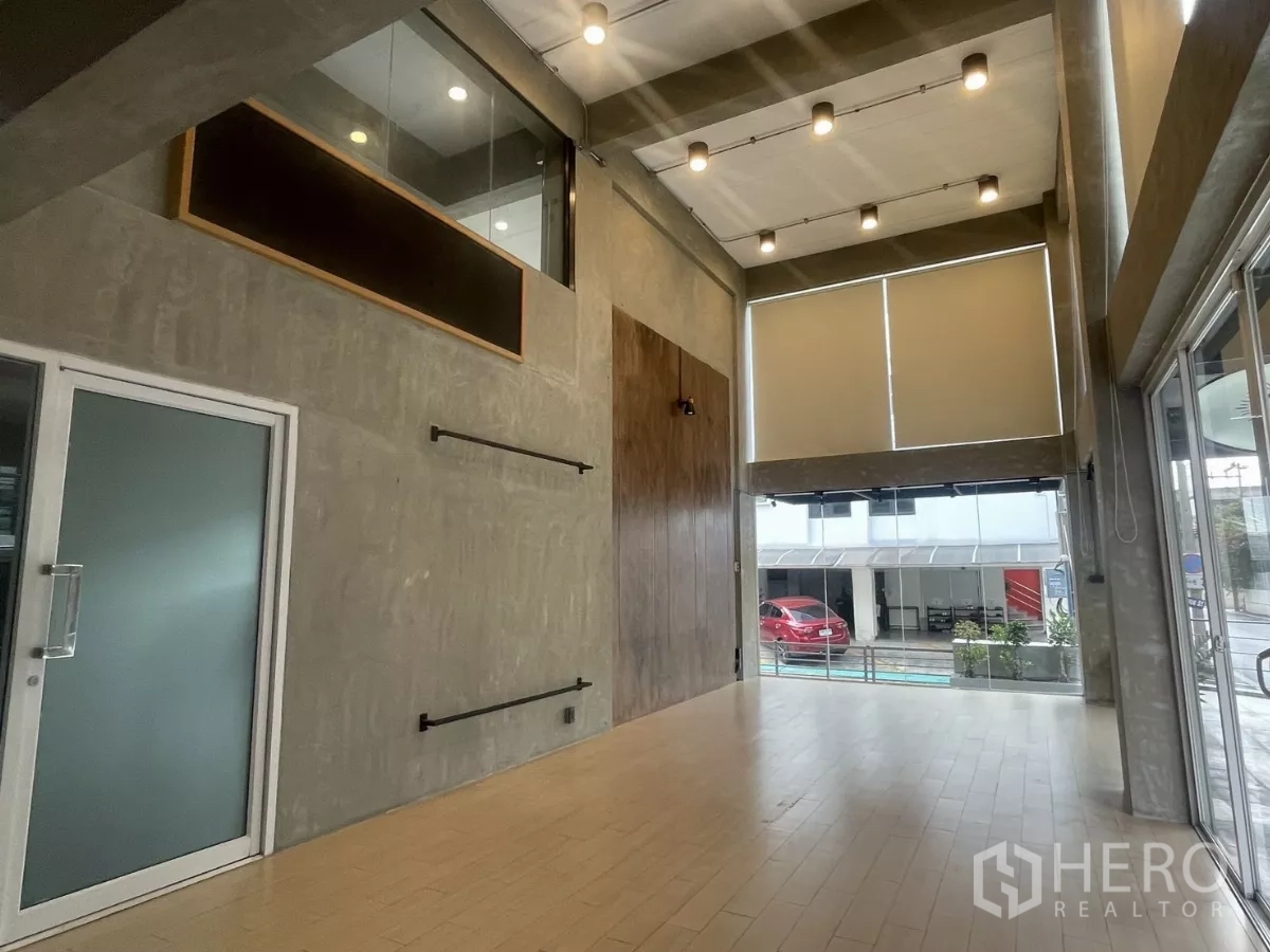 Home Office for rent in Suan Luang, Bangkok - Double-volume showroom space with floor-to-ceiling windows and spotlights.