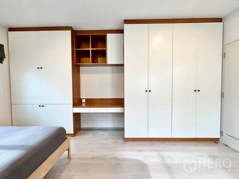 独立式住宅 出租或出售在Prawet, Bangkok - 卧室整面白色衣柜，内置书桌与开放格。
