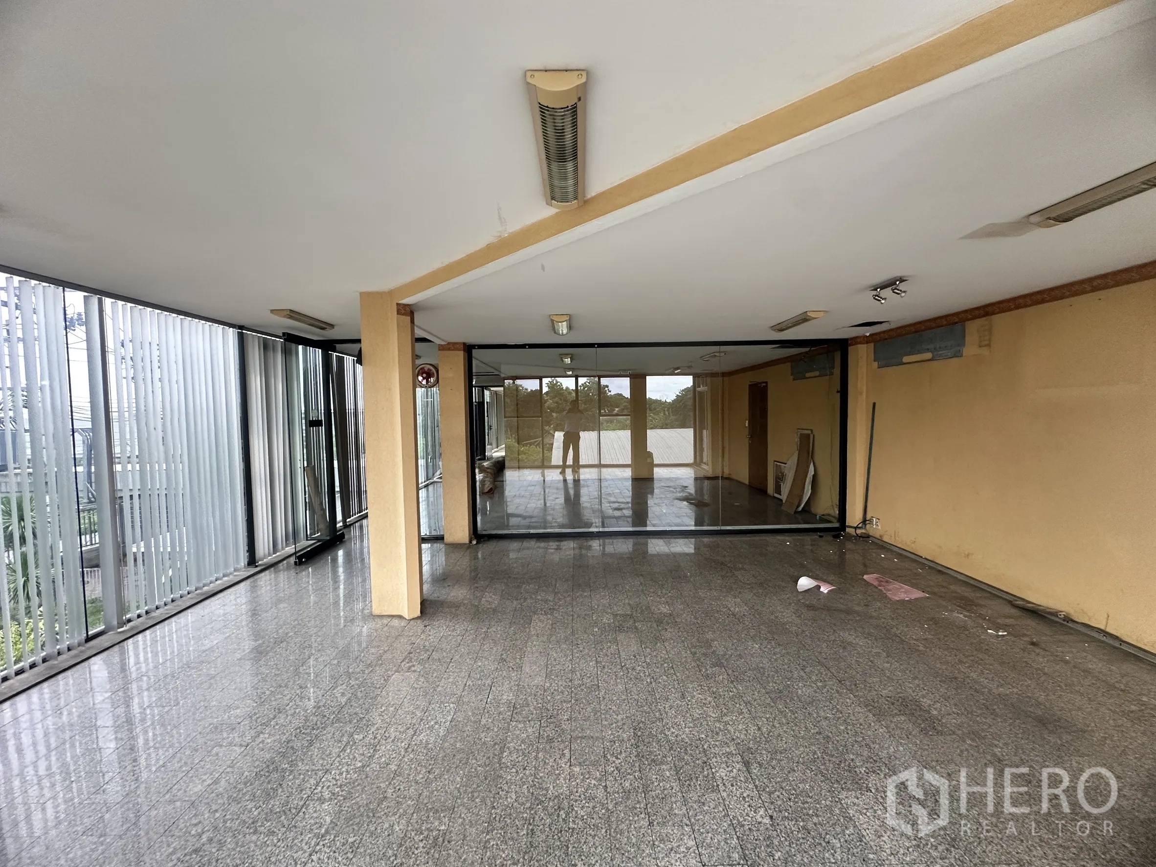 Factory for sale in Bang Bua Thong, Nonthaburi - Upper-level office space with floor-to-ceiling windows, blinds, and glass doors.