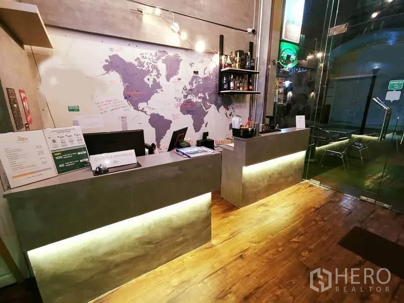 办公空间 出租或出售在Bang Rak, Bangkok - 工业风接待区，水泥前台、世界地图墙和玻璃入口。