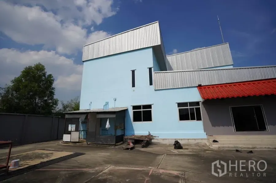 โรงงาน ขายในKhlong Luang, Pathum Thani - อาคารโรงงานสีฟ้าพร้อมหลังคาทรงฟันเลื่อยและชานโหลดสินค้า ในเขตคลองหลวง ปทุมธานี