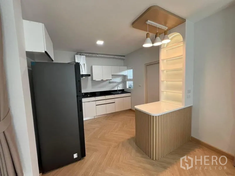 Detached House for rent in Bang Phli, Samut Prakan - Kitchen with breakfast counter, pendant lights, and built-in cabinetry.