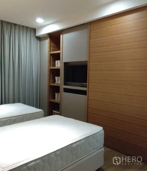 อพาร์ทเมนท์ ให้เช่าในKhlong Toei, Bangkok - ผนังเก็บของบิวท์อิน ตู้เลื่อน ชั้นวาง และทีวีในห้องนอนเตียงคู่