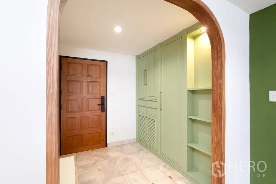คอนโด for rent in Watthana, Bangkok - โถงทางเข้าพร้อมประตูไม้ ซุ้มโค้ง และตู้บิวท์อินสีเขียวมิ้นต์.