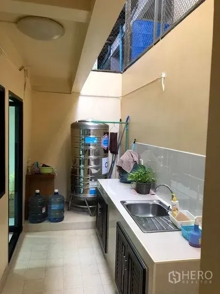 Home Office for rent in Khlong Toei, Bangkok - Covered utility kitchen with countertop sink, storage cabinets and stainless water tank.