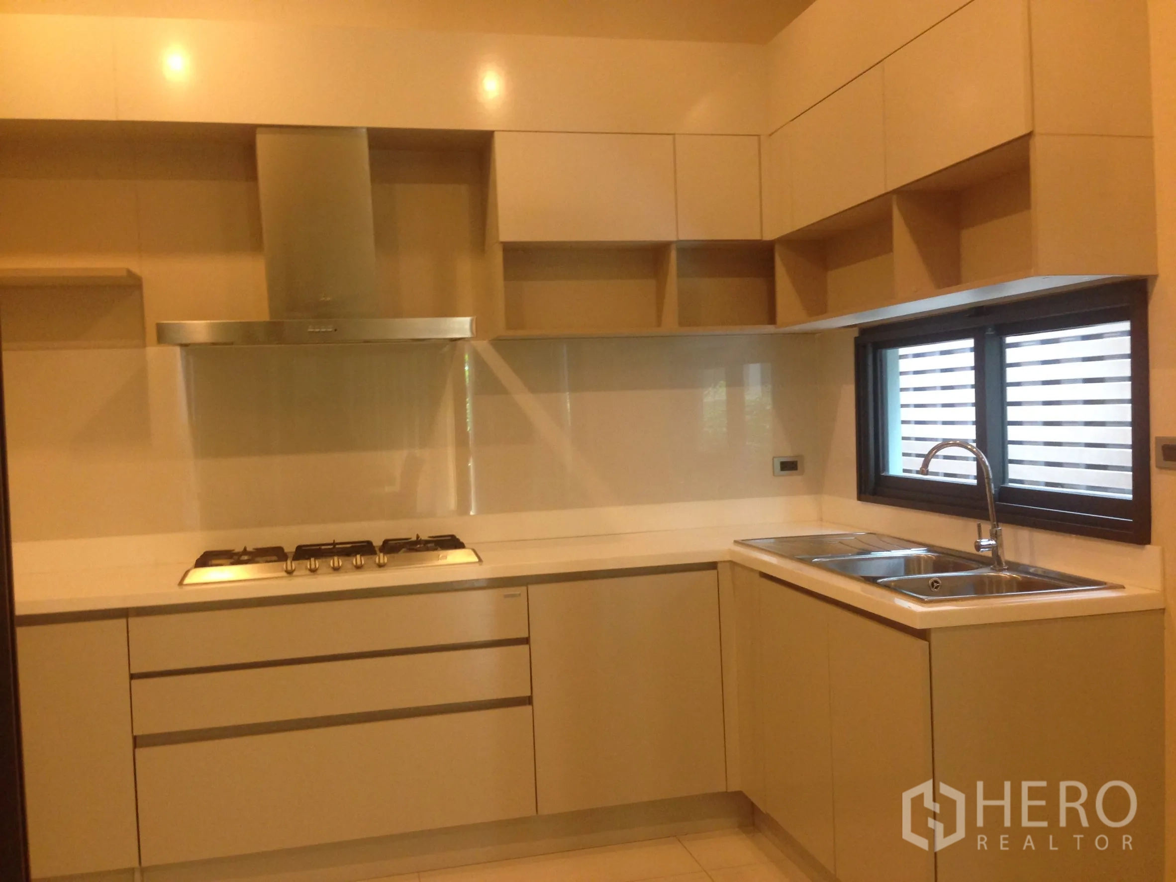 ทาวน์เฮาส์ ให้เช่าในBang Kapi, Bangkok - มุมมองห้องครัวรูปตัวแอล อ่างล้างจานคู่ ตู้เก็บของ และหน้าต่างรับแสง