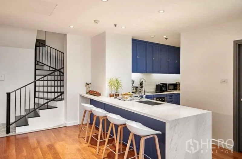 คอนโด ให้เช่าหรือขายในSathon, Bangkok - เคาน์เตอร์ครัวท็อปหินอ่อนพร้อมสตูลบาร์ ถัดจากบันไดวนขึ้นชั้นลอย