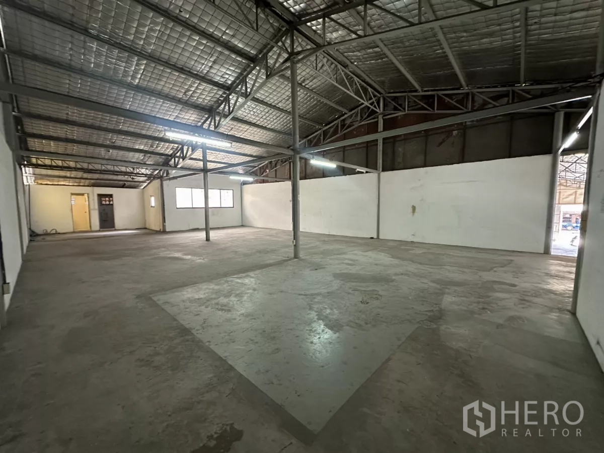Warehouse for rent in Suan Luang, Bangkok - Clear-span warehouse from another angle with center columns and concrete floor.