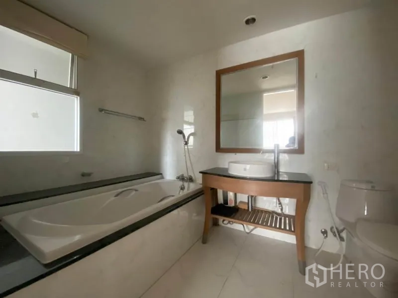 คอนโด ให้เช่าในWatthana, Bangkok - ห้องน้ำมีอ่างอาบน้ำยาว เคาน์เตอร์อ่างล้างหน้า กระจกบานใหญ่ และโถสุขภัณฑ์