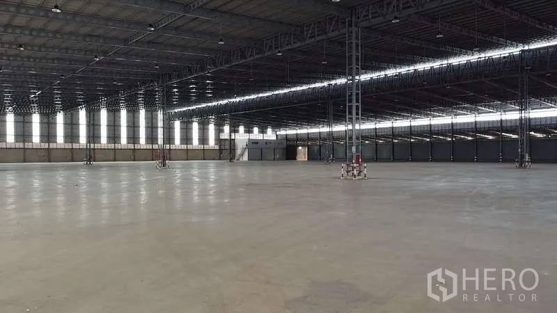 Warehouse for rent in Bang Phli, Samut Prakan - Large industrial warehouse showing metal beam ceiling, bright natural light, and an open floor plate.