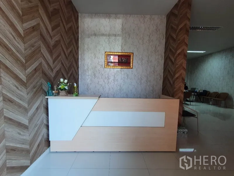 Factory for sale in Lam Luk Ka, Pathum Thani - Reception desk in office area with wood-pattern feature wall.