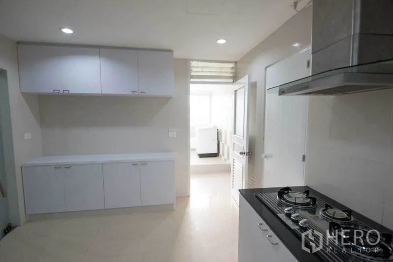 公寓 出租在Khlong Toei, Bangkok - 厨房一角，燃气灶、抽油烟机与充足白色柜体。