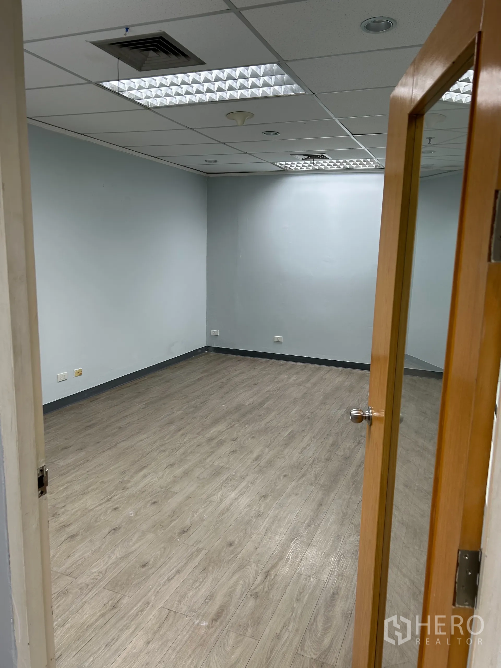 办公空间 出租在Khlong Toei, Bangkok - 独立小房间，带玻璃门、素雅墙面、木纹地板与空调出风口。