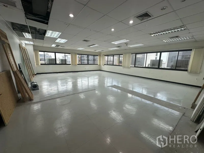 Office Space for rent in Khlong Toei, Bangkok - Spacious 84 sqm office floor with large windows on two sides and easy-care tiled flooring.