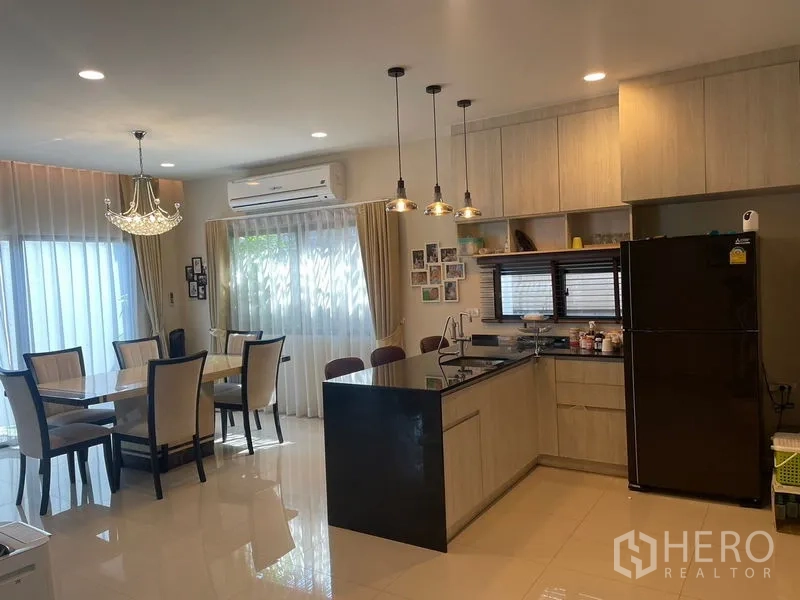 บ้าน ให้เช่าหรือขายในLam Luk Ka, Pathum Thani - โซนรับประทานอาหารและครัวตะวันตกสว่างไสว มีไอแลนด์หินสีดำและโคมไฟแขวน