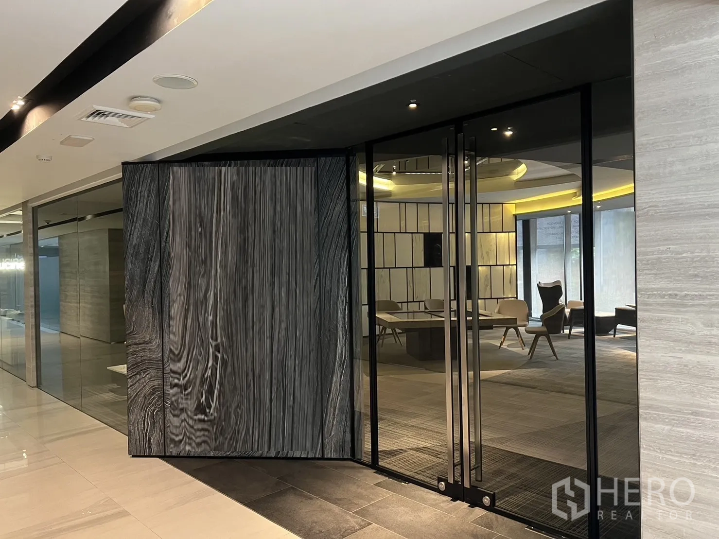 零售空间 出租在Watthana, Bangkok - 玻璃门店入口，巨型木质旋转门通向时尚展厅与座椅区。