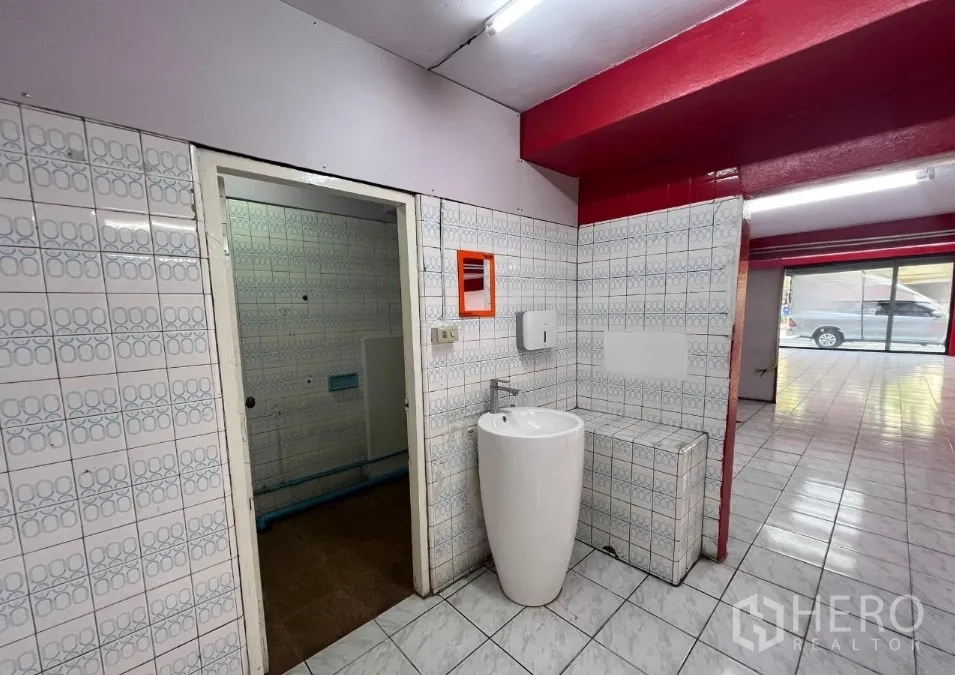 อาคารพาณิชย์ ให้เช่าในSuan Luang, Bangkok - มุมล้างมือชั้นล่าง มีอ่างทรงกระบอก ผนังกระเบื้อง และมองออกไปยังหน้าร้าน