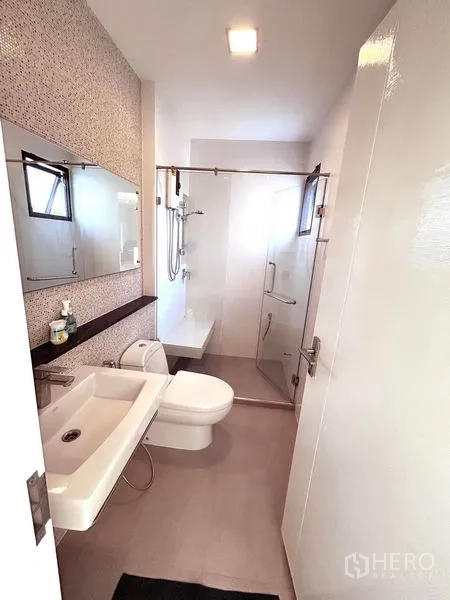 Detached House for rent or sale in Prawet, Bangkok - Modern bathroom with glass shower enclosure and large mirror.