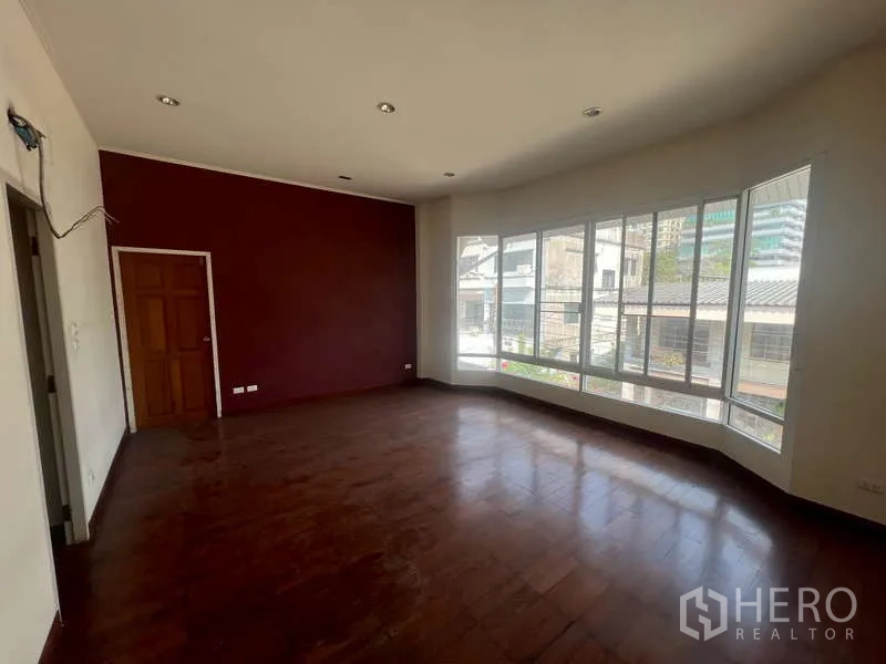 独立式住宅 出租在Watthana, Bangkok - 大面积二楼房间，转角落地窗与酒红色重点墙。