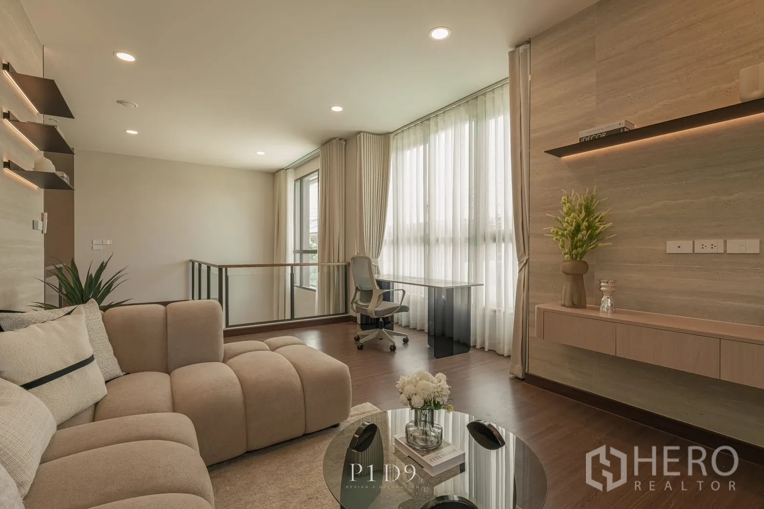 Detached House for rent in Bang Phli, Samut Prakan - Cozy lounge with a beige sectional sofa, work desk and soft recessed lighting.