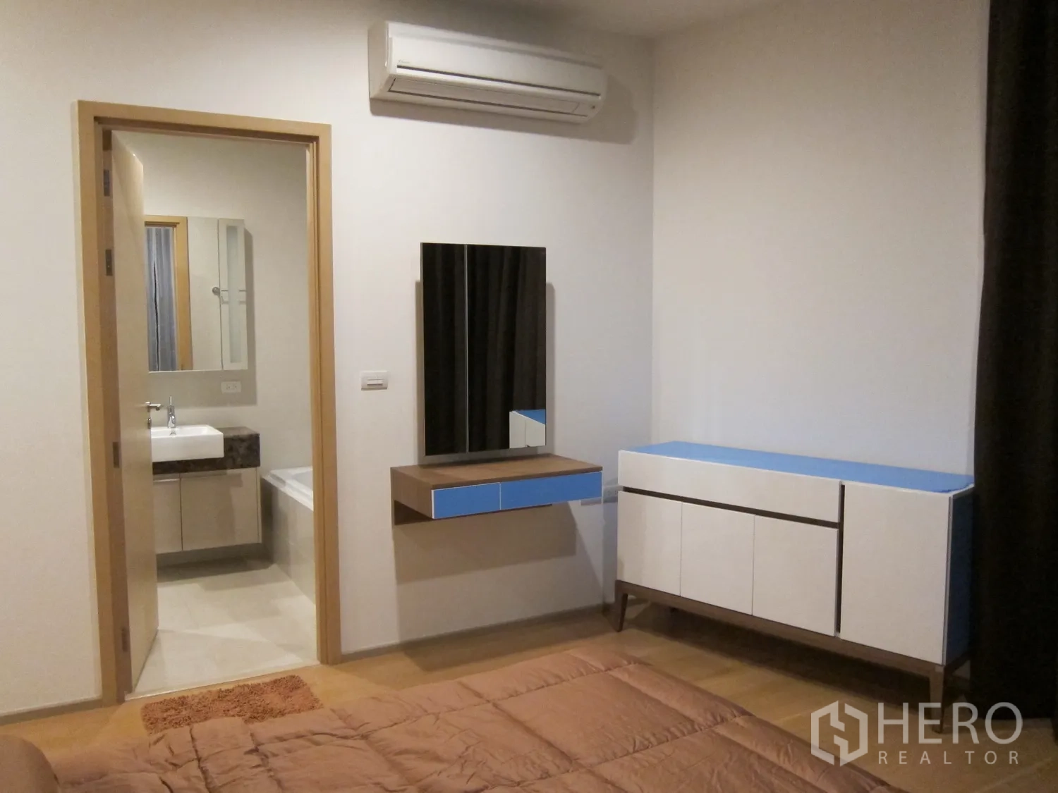 Condominium for rent in Watthana, Bangkok - Primary bedroom with ensuite bathroom, wall mirror vanity, and air-conditioning.