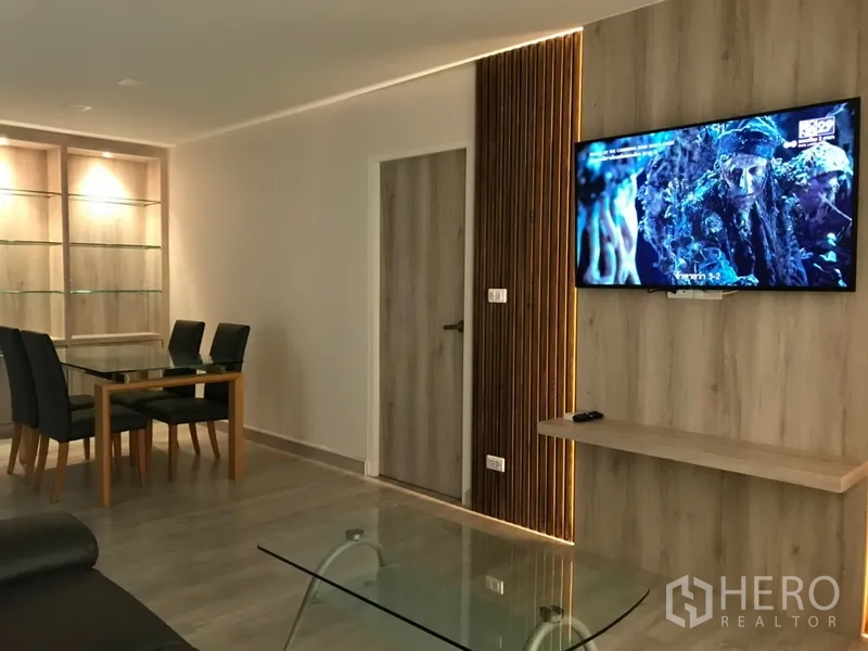 คอนโด ให้เช่าในWatthana, Bangkok - ห้องนั่งเล่นและรับประทานอาหารสไตล์โมเดิร์น ผนังทีวีลายไม้ โต๊ะกลางกระจก และตู้โชว์บิลท์อิน