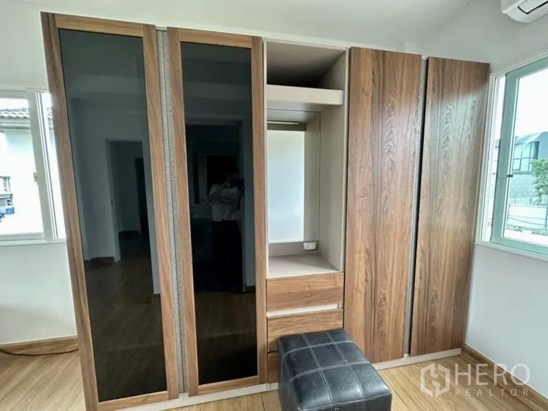 Townhouse for rent in Bang Phli, Samut Prakan - Built-in wood wardrobes with mirrored panels and a small dressing nook.