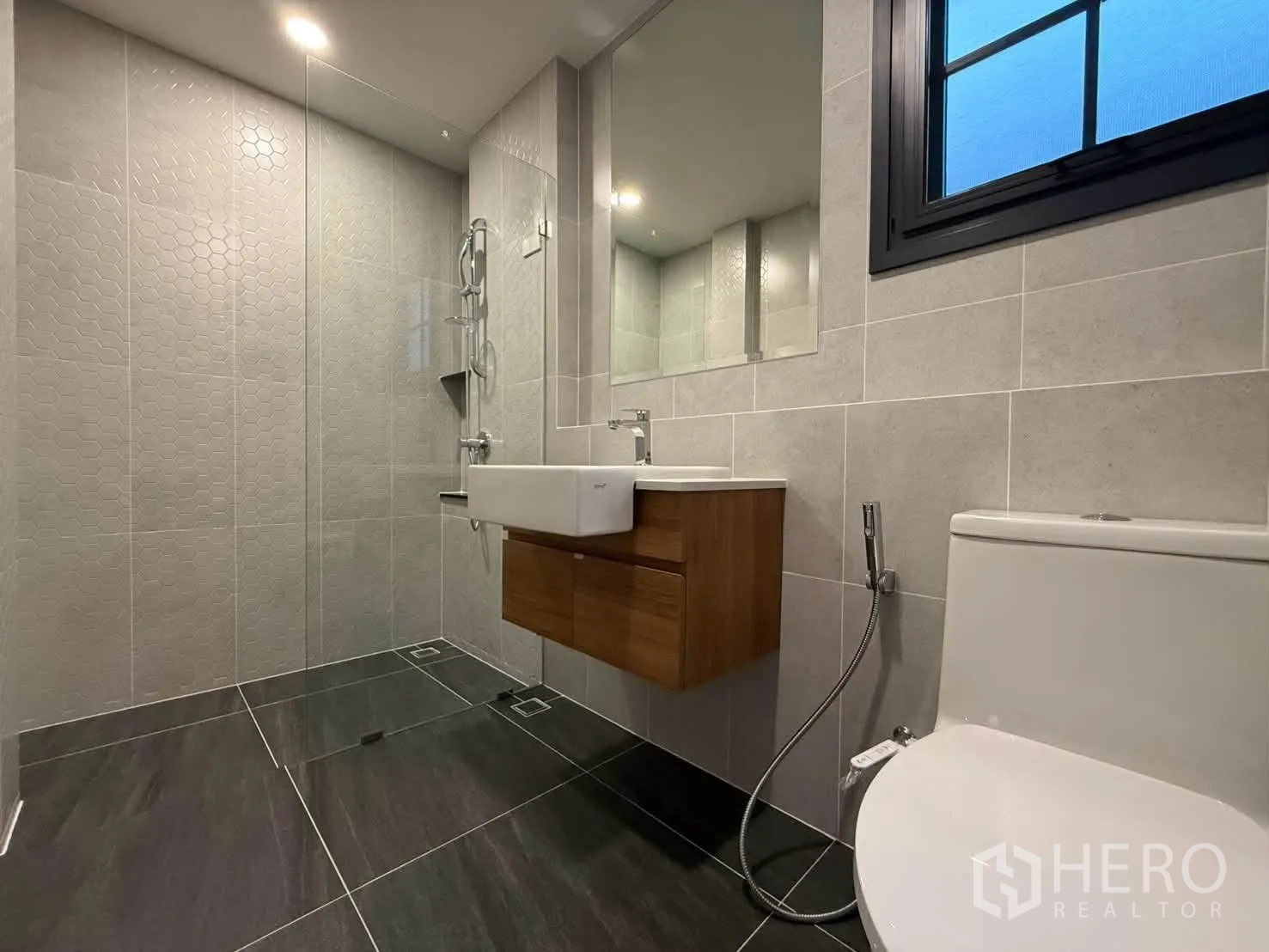 独栋房屋 for rent in Bang Phli, Samut Prakan - 卫生间带玻璃步入式淋浴、洗手台、马桶与深色地砖。