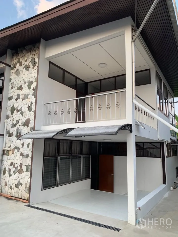 独栋房屋 for rent in Phra Khanong, Bangkok - 外立面一角，石材点缀墙与带顶阳台。