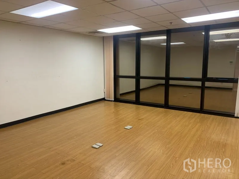 办公空间 出租在Bang Rak, Bangkok - 宽敞房间，整面深色框玻璃窗，百叶帘与地面插座。