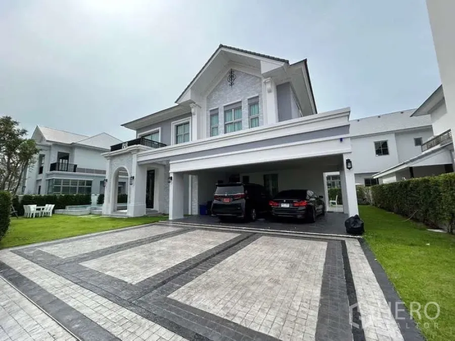Detached House for rent or sale in Bang Phli, Samut Prakan - Front exterior of luxury detached house showing columns, manicured lawn and spacious driveway.