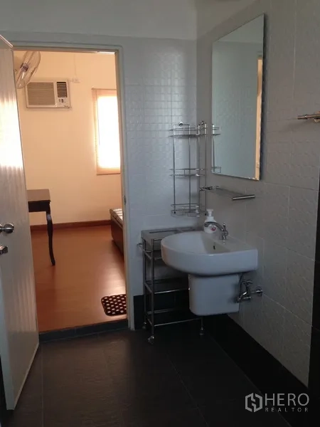 独立式住宅 出售在Phra Khanong, Bangkok - 整洁浴室，墙镜、小型面盆与瓷砖饰面。