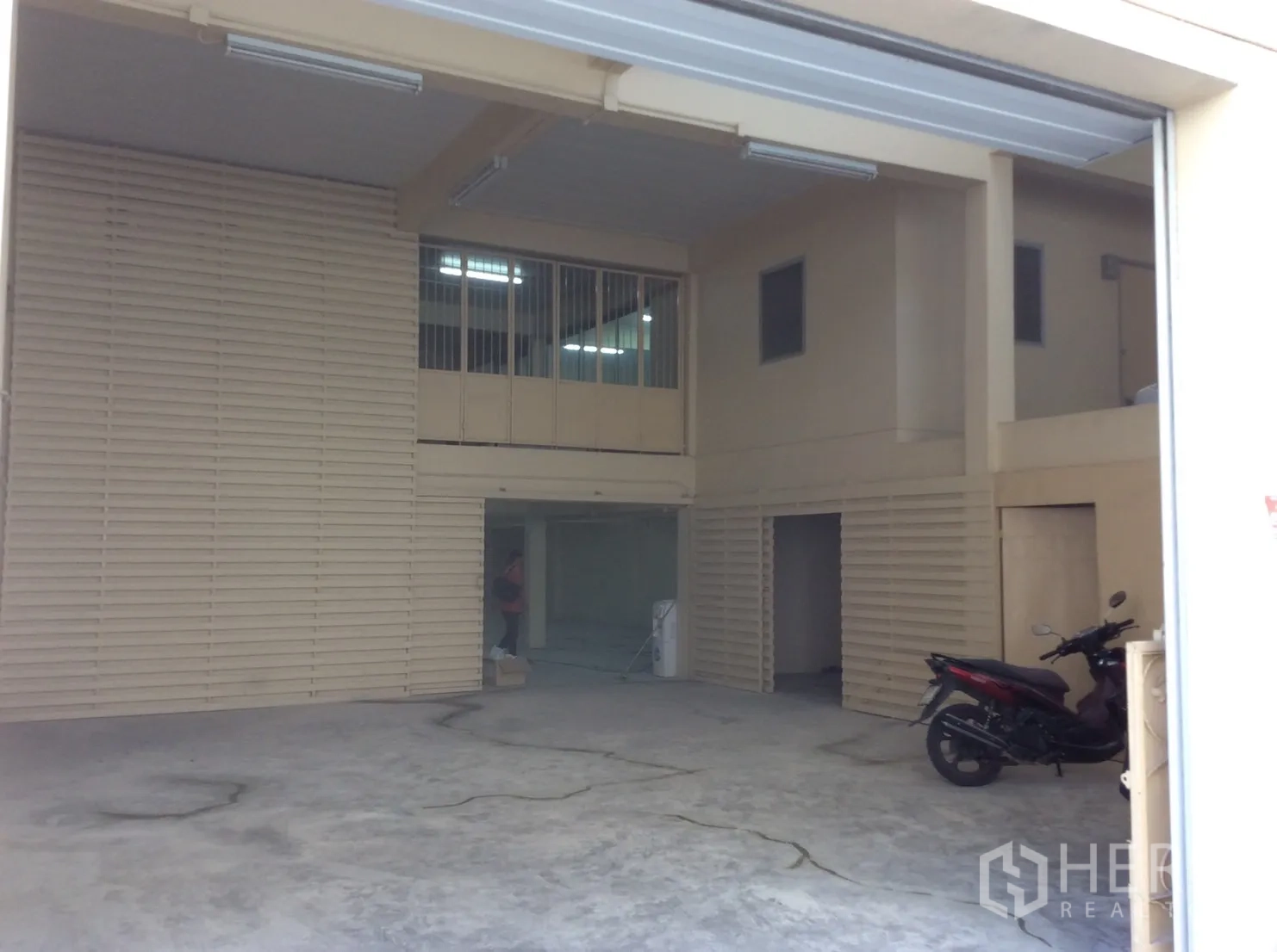 工厂 for rent in Thung Khru, Bangkok - 一层装卸区，混凝土地面、宽幅卷闸门与夹层房间。