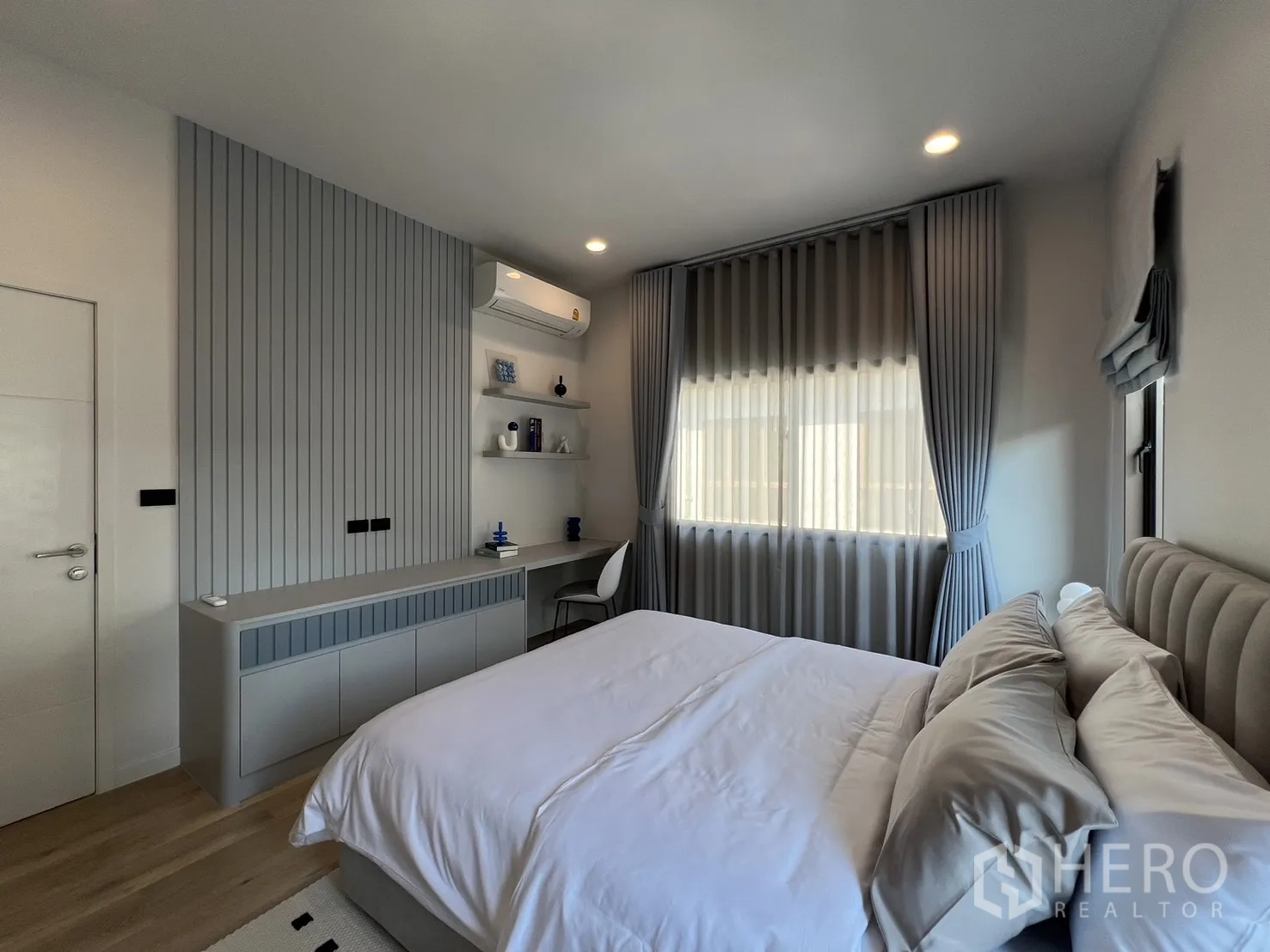 Detached House for rent or sale in Bang Kapi, Bangkok - Corridor with tall matte grey wardrobes and wood flooring.